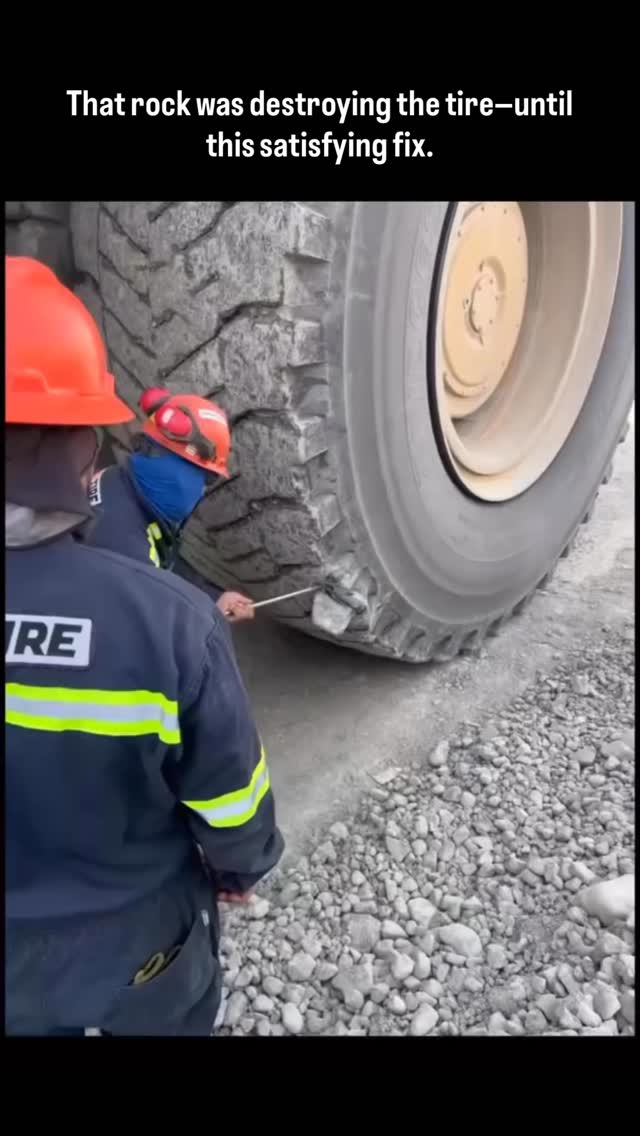 This clip shows workers using a long metal rod to carefully pry a large rock wedged deep inside the …