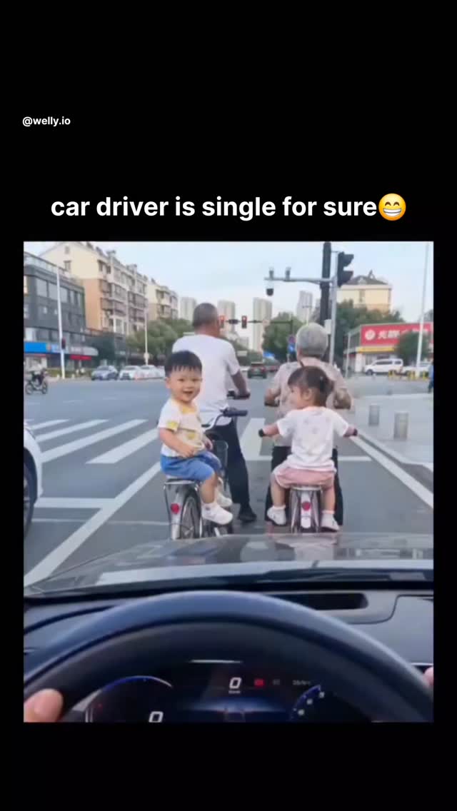 The video captures a street scene in an urban area of China, likely filmed from inside a car at a tr…